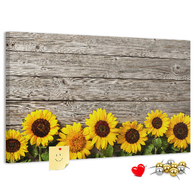 Lavagna di sughero con stampa di girasoli su sfondo di assi di legno