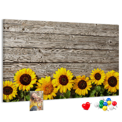 Lavagna di sughero con stampa di girasoli su sfondo di assi di legno