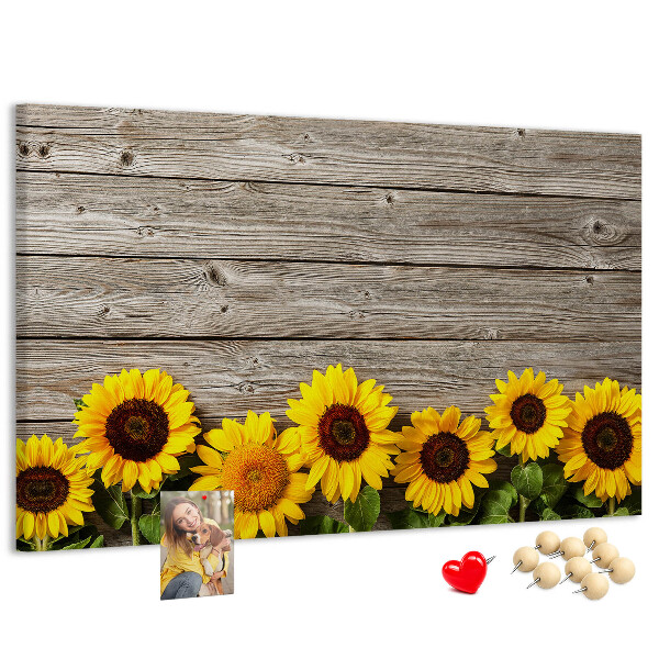 Lavagna di sughero con stampa di girasoli su sfondo di assi di legno