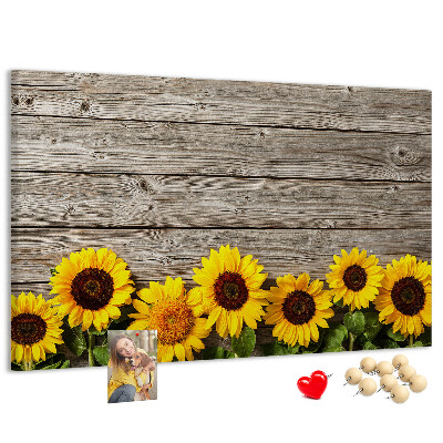Lavagna di sughero con stampa di girasoli su sfondo di assi di legno