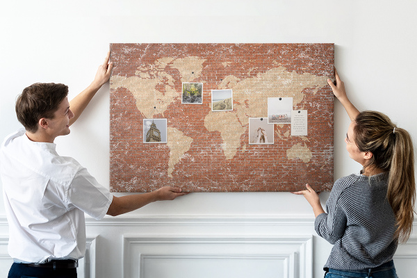 Bacheca in sughero con stampa di una mappa del mondo su muro di mattoni