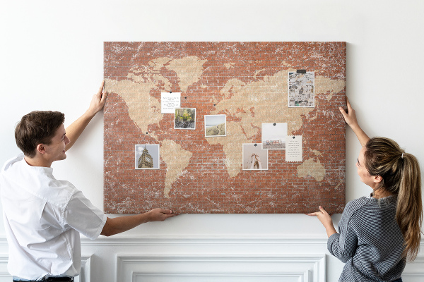 Bacheca in sughero con stampa di una mappa del mondo su muro di mattoni