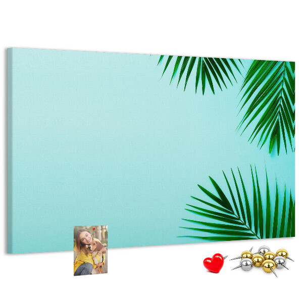Lavagna di sughero con stampa di foglie tropicali su sfondo blu