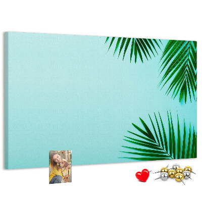 Lavagna di sughero con stampa di foglie tropicali su sfondo blu