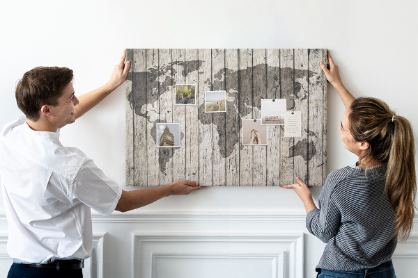 Bacheca in sughero con stampa di una mappa del mondo su sfondo di assi di legno