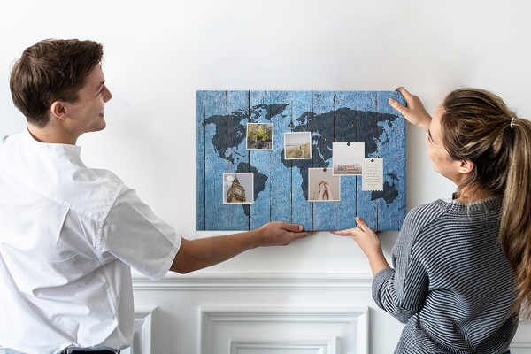 Bacheca in sughero con mappa del mondo su sfondo effetto legno