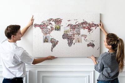 Bacheca in sughero con stampa del mondo su sfondo di muro di mattoni