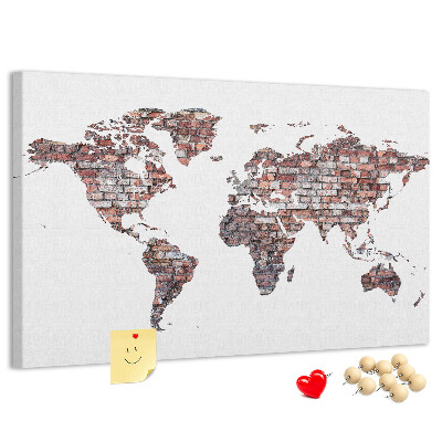 Bacheca in sughero con stampa del mondo su sfondo di muro di mattoni