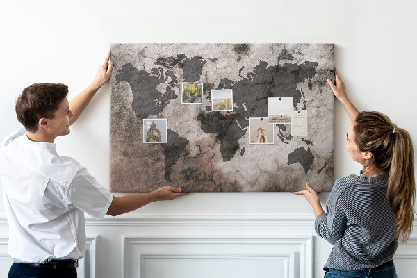 Bacheca in sughero con stampa di una mappa del mondo effetto ruggine su sfondo in cemento