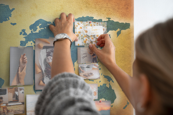 Bacheca in sughero con mappa del mondo su sfondo carta marrone