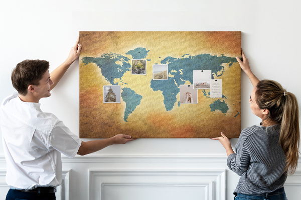 Bacheca in sughero con mappa del mondo su sfondo carta marrone