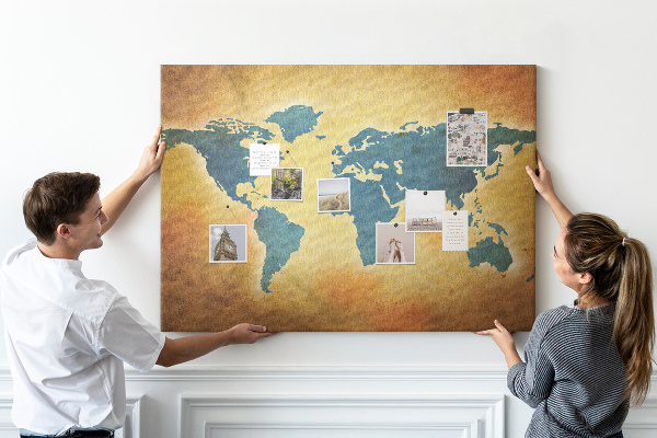 Bacheca in sughero con mappa del mondo su sfondo carta marrone
