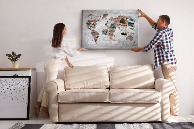 Lavagna di sughero con stampa mappa del mondo su sfondo di muro di mattoni