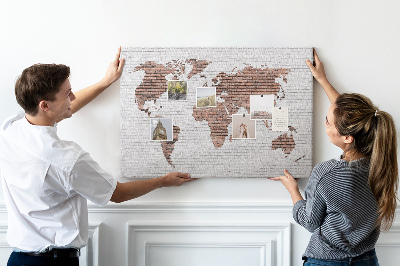 Lavagna di sughero con stampa mappa del mondo su sfondo di muro di mattoni