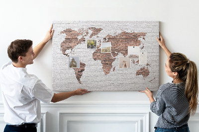 Lavagna di sughero con stampa mappa del mondo su sfondo di muro di mattoni