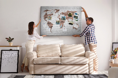 Lavagna di sughero con stampa mappa del mondo su sfondo di muro di mattoni