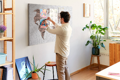 Lavagna di sughero con stampa mappa del mondo su sfondo di muro di mattoni