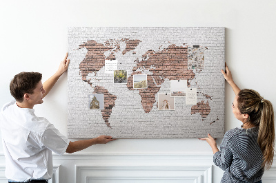 Lavagna di sughero con stampa mappa del mondo su sfondo di muro di mattoni