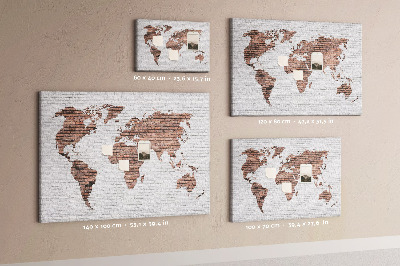 Lavagna di sughero con stampa mappa del mondo su sfondo di muro di mattoni