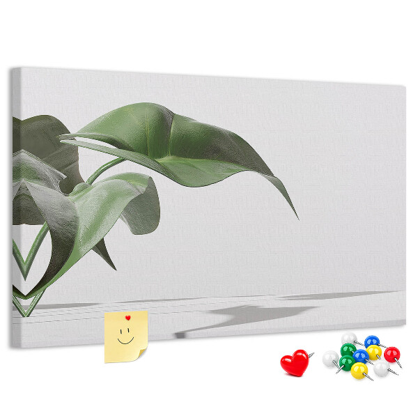 Lavagna di sughero con foglie delicate su sfondo minimalista