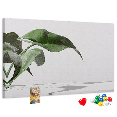Lavagna di sughero con foglie delicate su sfondo minimalista