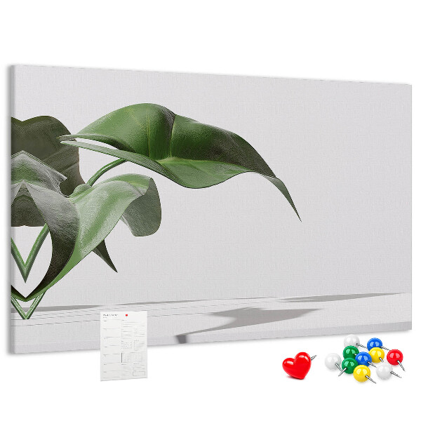 Lavagna di sughero con foglie delicate su sfondo minimalista