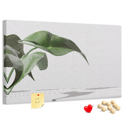 Lavagna di sughero con foglie delicate su sfondo minimalista