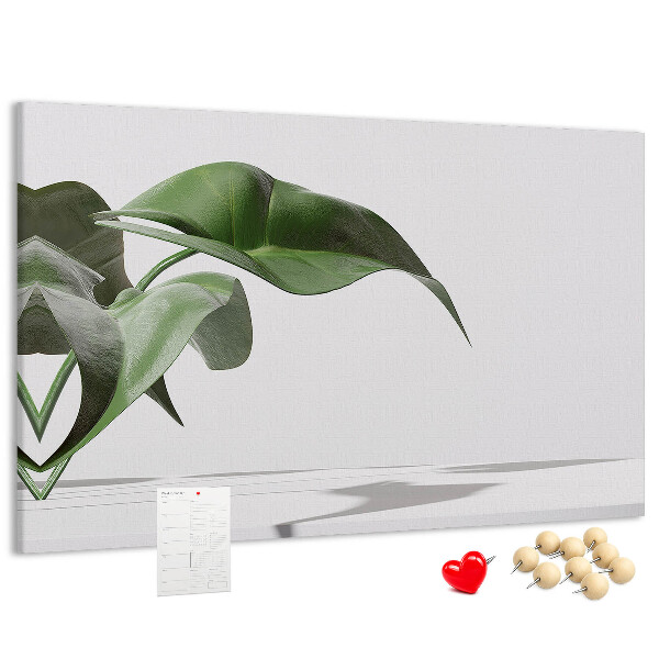 Lavagna di sughero con foglie delicate su sfondo minimalista