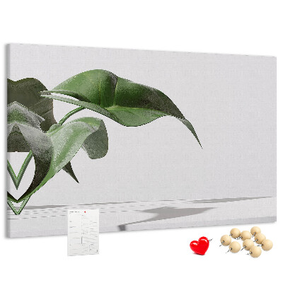 Lavagna di sughero con foglie delicate su sfondo minimalista