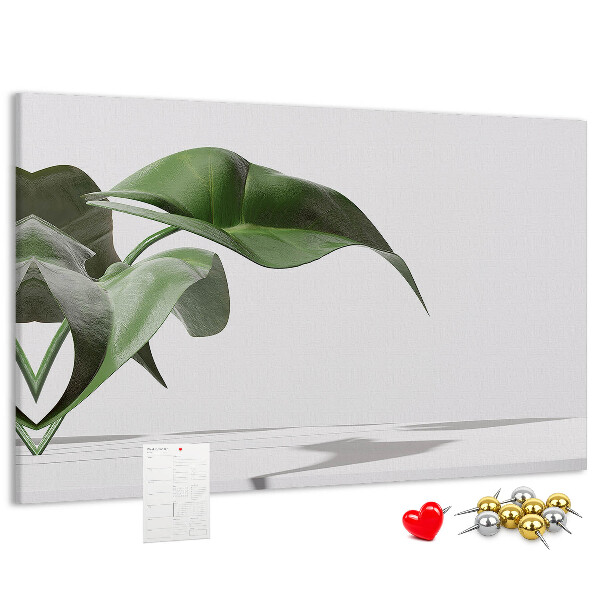 Lavagna di sughero con foglie delicate su sfondo minimalista