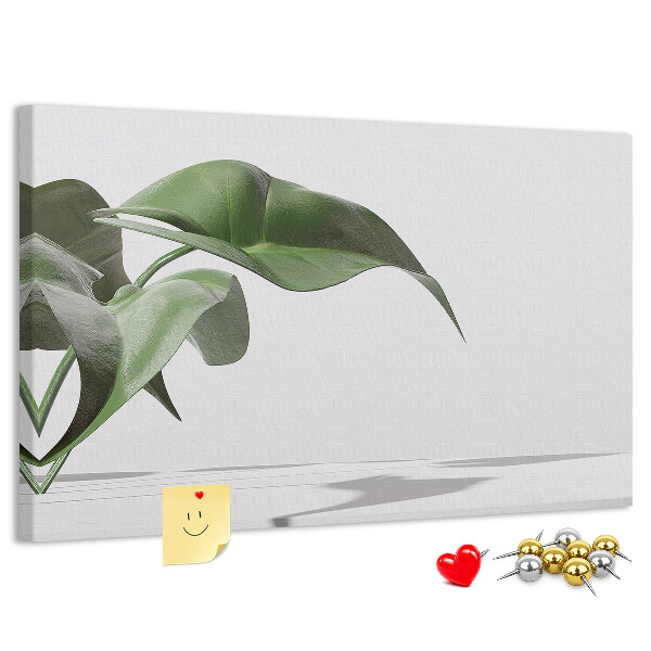 Lavagna di sughero con foglie delicate su sfondo minimalista
