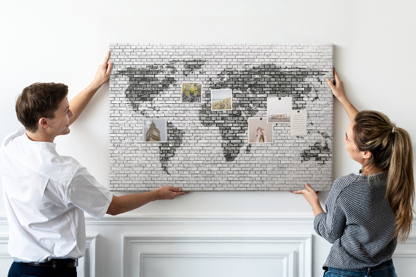 Bacheca in sughero con stampa di una mappa del mondo su muro di mattoni