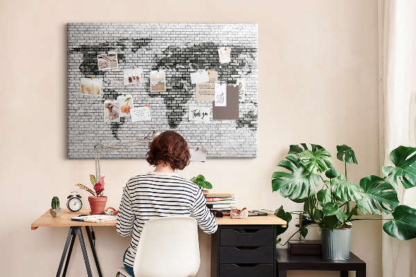 Bacheca in sughero con stampa di una mappa del mondo su muro di mattoni