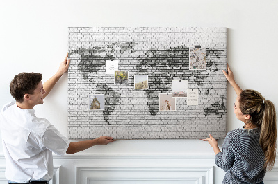 Bacheca in sughero con stampa di una mappa del mondo su muro di mattoni