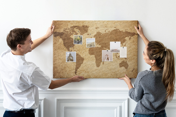 Lavagna di sughero con stampa antica mappa del mondo su sfondo bronzo