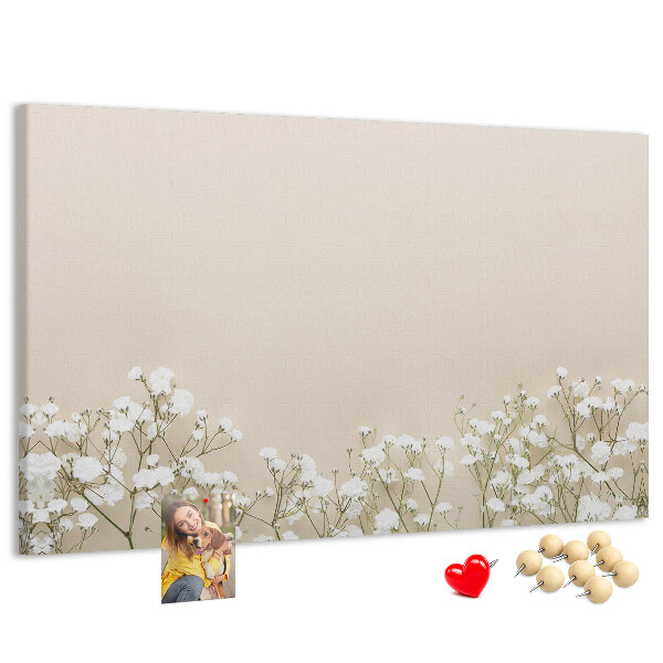 Lavagna di sughero con fiori delicati su sfondo neutro