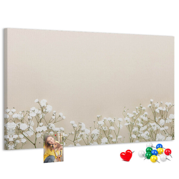Lavagna di sughero con fiori delicati su sfondo neutro