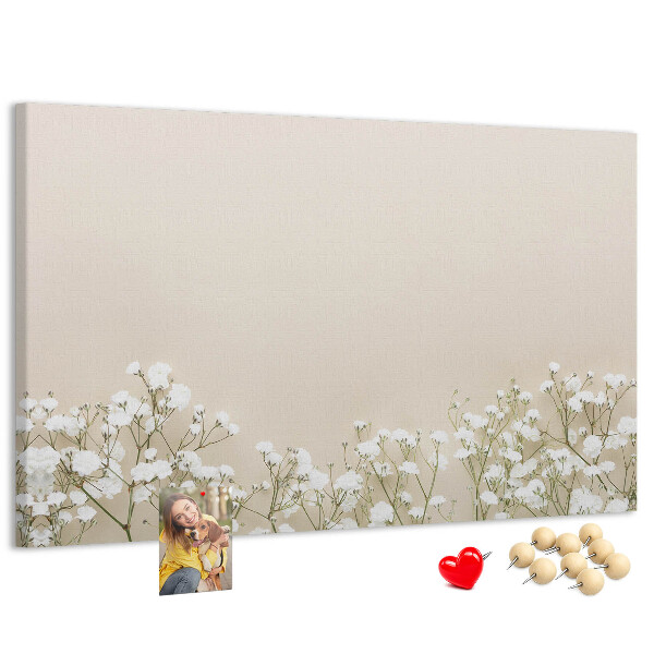 Lavagna di sughero con fiori delicati su sfondo neutro