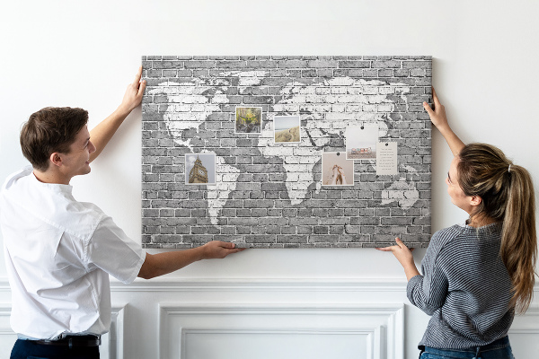 Bacheca in sughero con stampa di una mappa del mondo su muro di mattoni