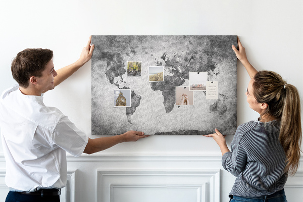 Lavagna di sughero con vecchia mappa del mondo nei toni del grigio