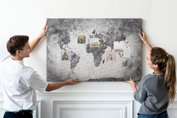 Lavagna di sughero con vecchia mappa del mondo nei toni del grigio