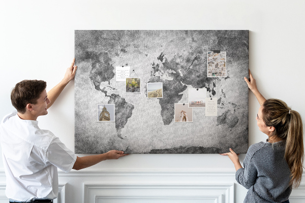 Lavagna di sughero con vecchia mappa del mondo nei toni del grigio