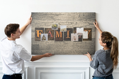 Lavagna di sughero con stampa di lettere di famiglia su sfondo in legno