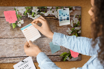 Bacheca in sughero con stampa di fiori su sfondo di tavola in legno