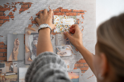 Lavagna di sughero con mappa del mondo su muro di mattoni