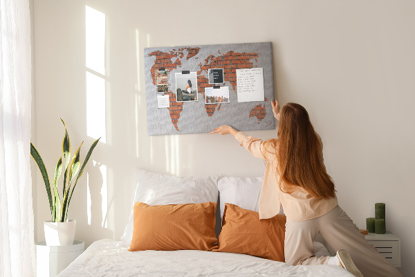 Lavagna di sughero con mappa del mondo su muro di mattoni