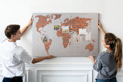 Lavagna di sughero con mappa del mondo su muro di mattoni