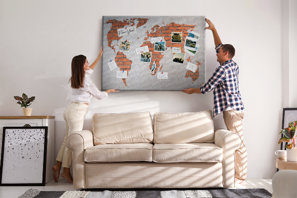 Lavagna di sughero con mappa del mondo su muro di mattoni