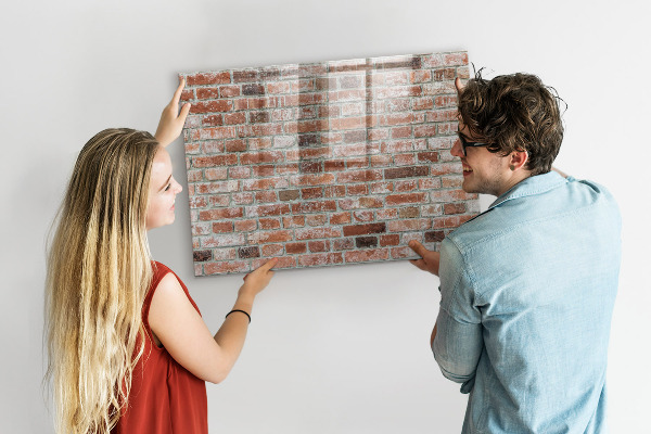 Lavagna magnetica con pennarelli Pannello fotografico su un muro di mattoni