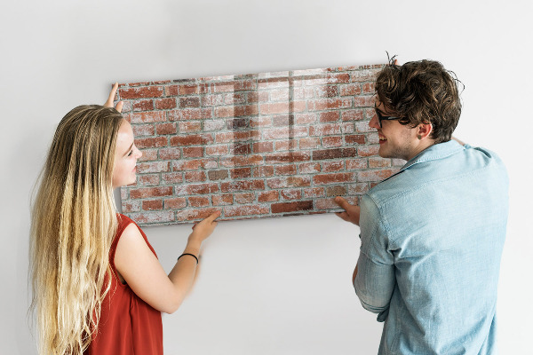 Lavagna magnetica con pennarelli Pannello fotografico su un muro di mattoni